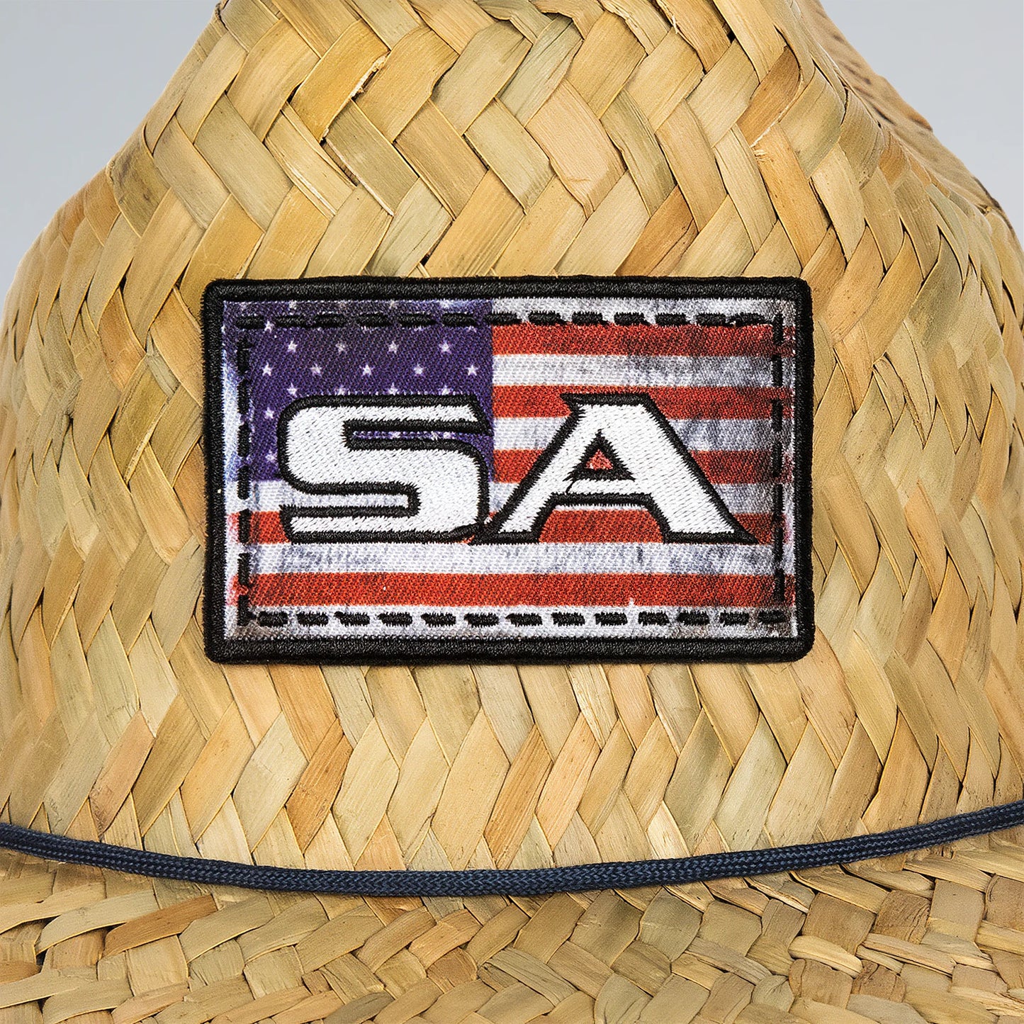 Woven hat with an American flag patch featuring 'SA' on a plain background