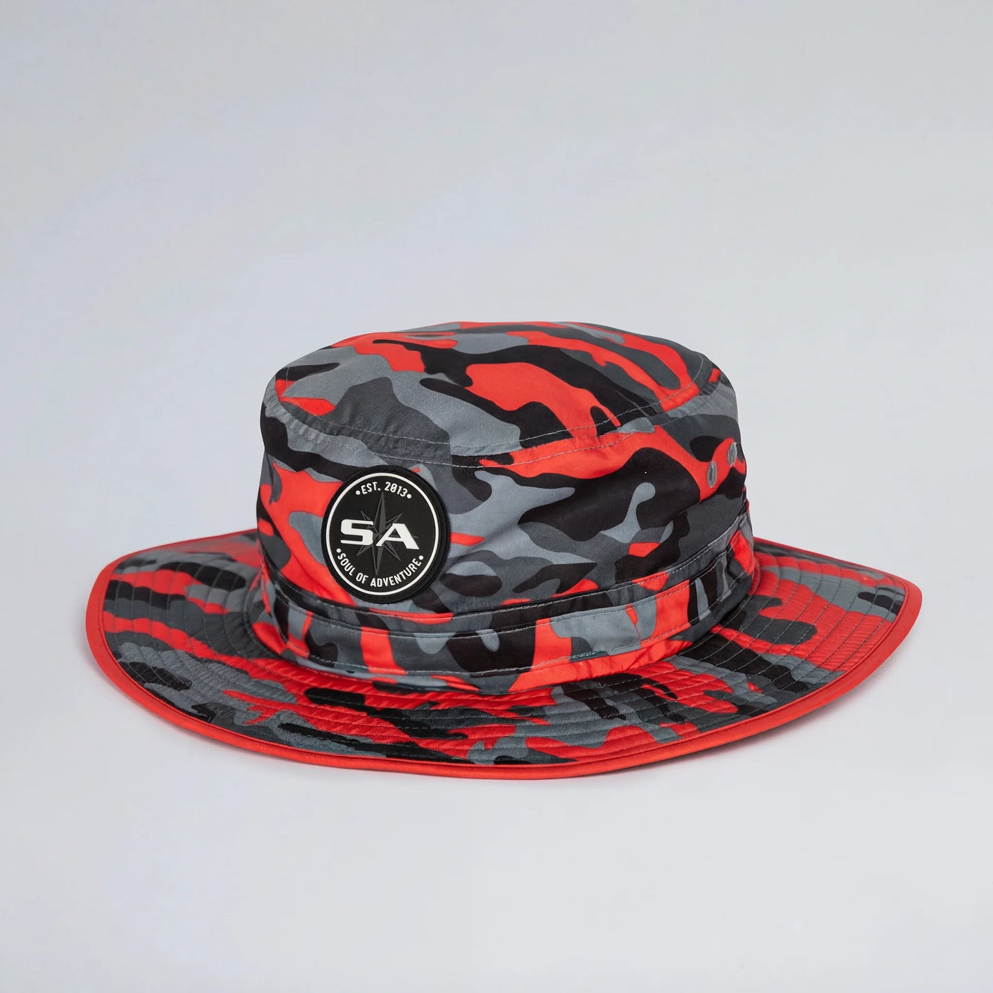 Red and gray camouflage bucket hat with a logo on a light gray background