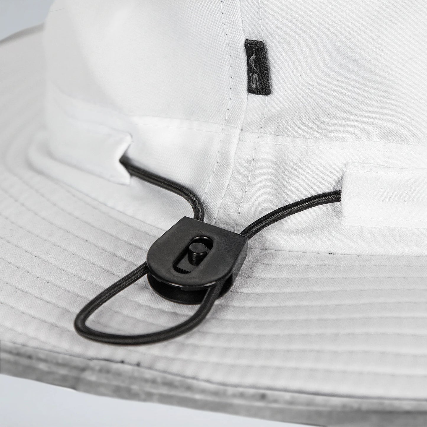 Close-up of a white shirt with a black cord and clip on a light gray background