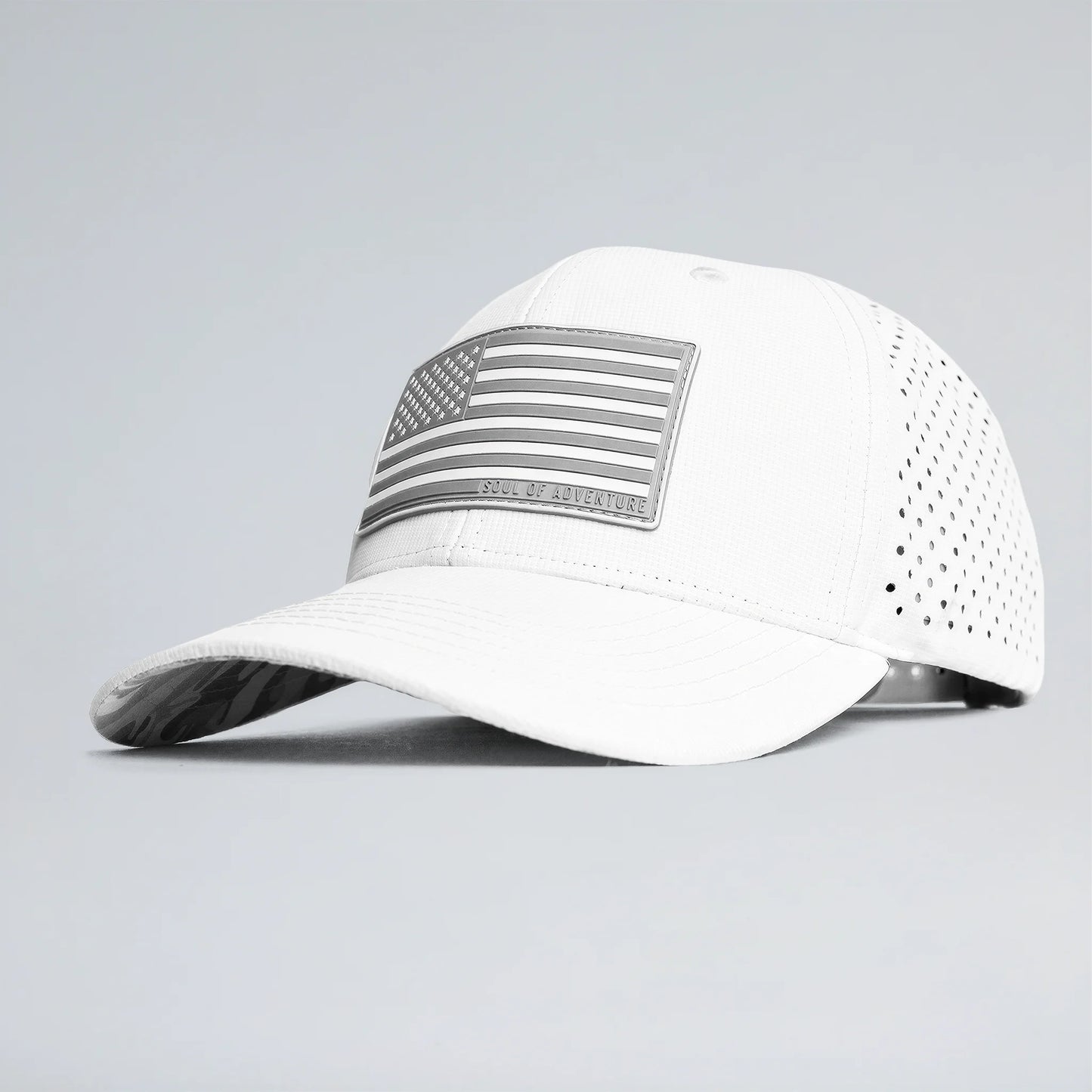 White baseball cap with an American flag patch on a gray background
