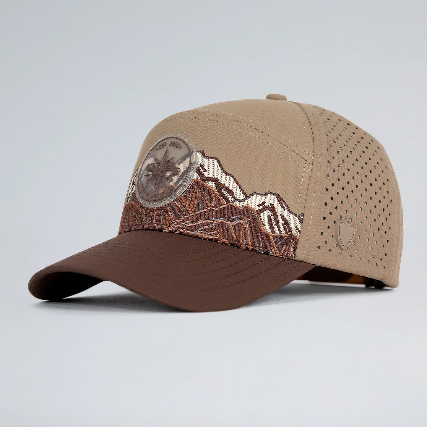 Brown and beige baseball cap with mountain design on a light gray background