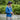 Man fishing wearing a navy Bucket hat by a river with greenery in the background