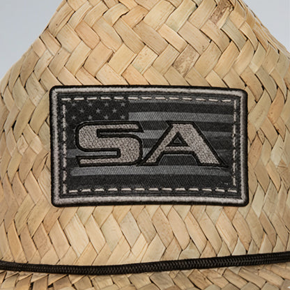 Woven straw hat with a black 'SA' patch on a neutral background