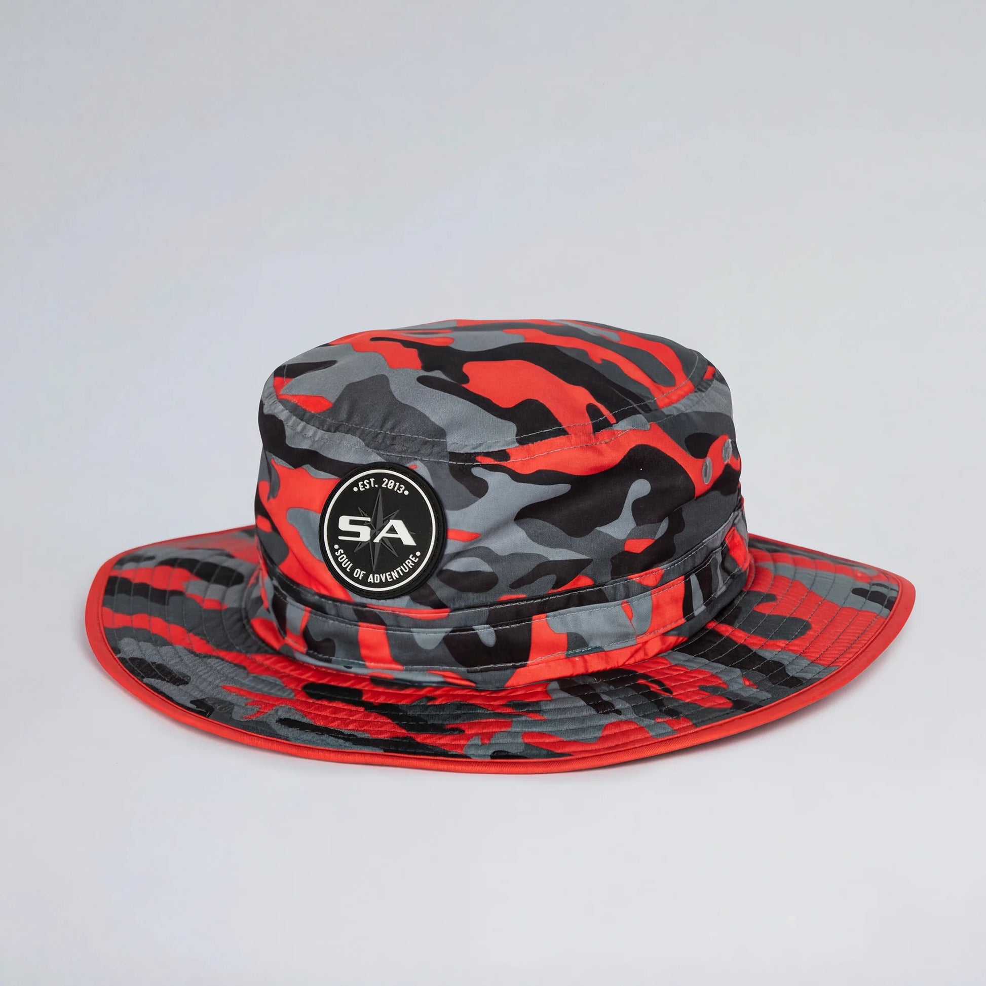 Red and gray camouflage bucket hat with a logo on a light gray background
