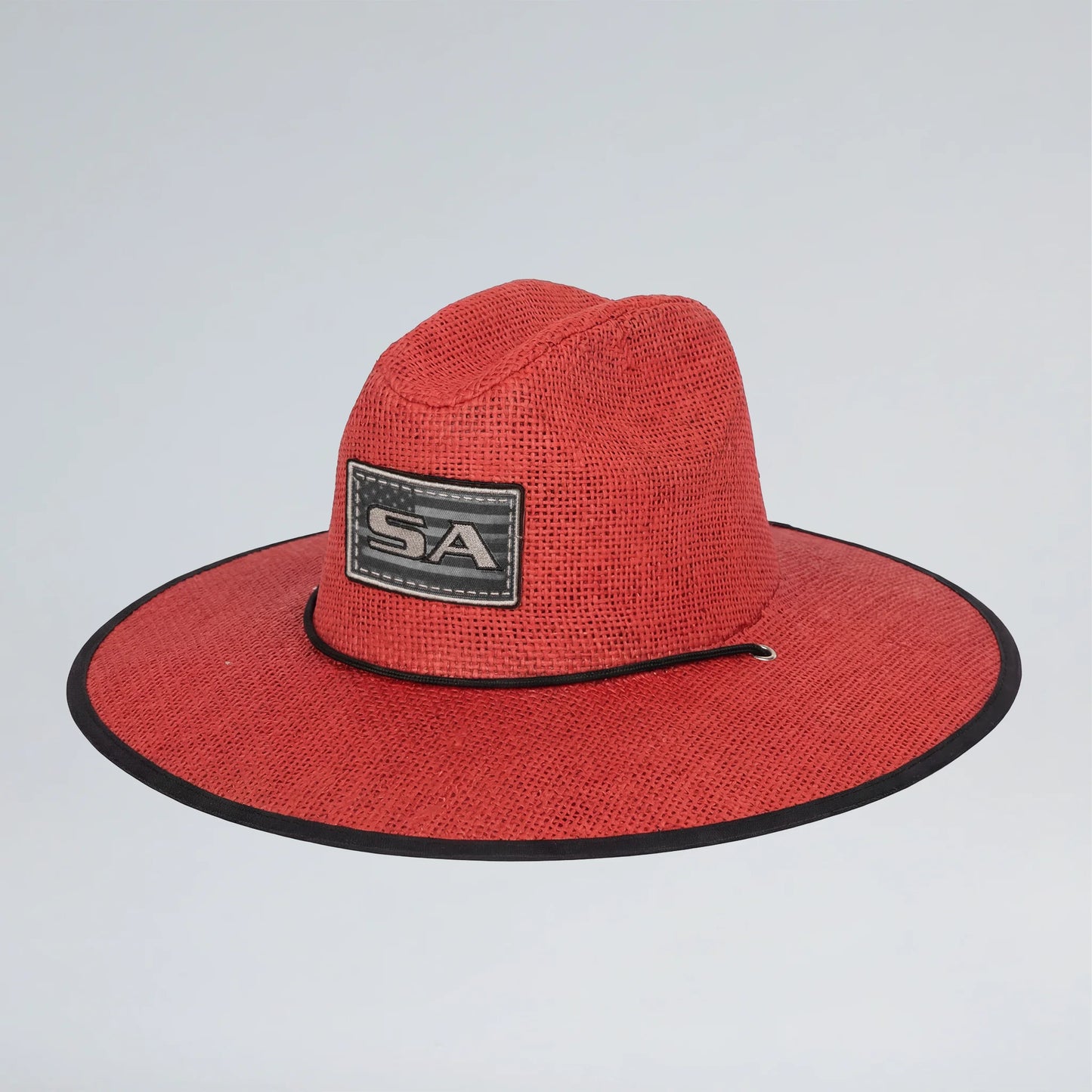 Red straw hat with a black brim and 'SA' logo on a light gray background