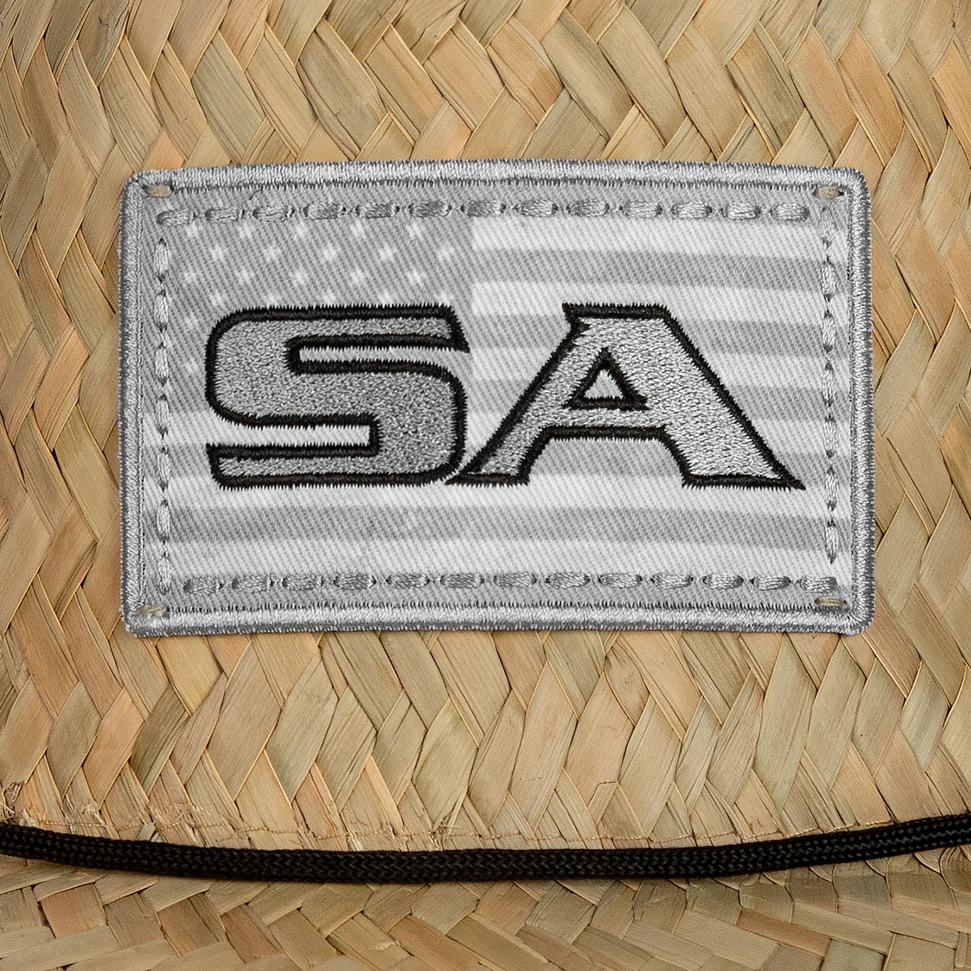 Patch with 'SA' on a woven surface