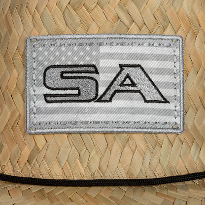Patch with 'SA' on a woven surface