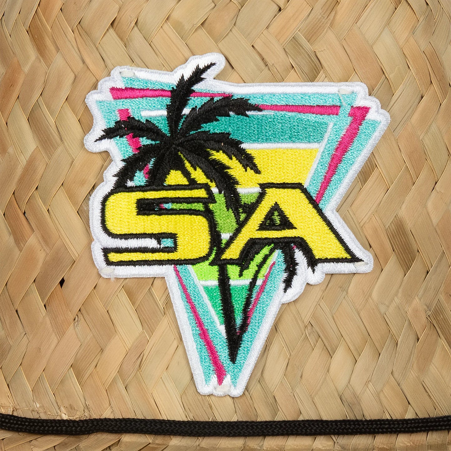 Colorful patch with 'SA' and palm tree design on a woven surface