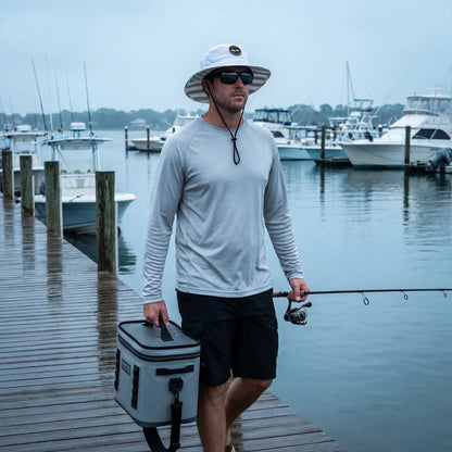 Man walking by dock wearing a white and grey american flag bucket hat