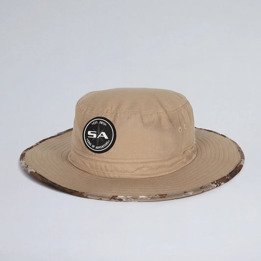 Beige bucket hat with camouflage brim and logo on a light gray background