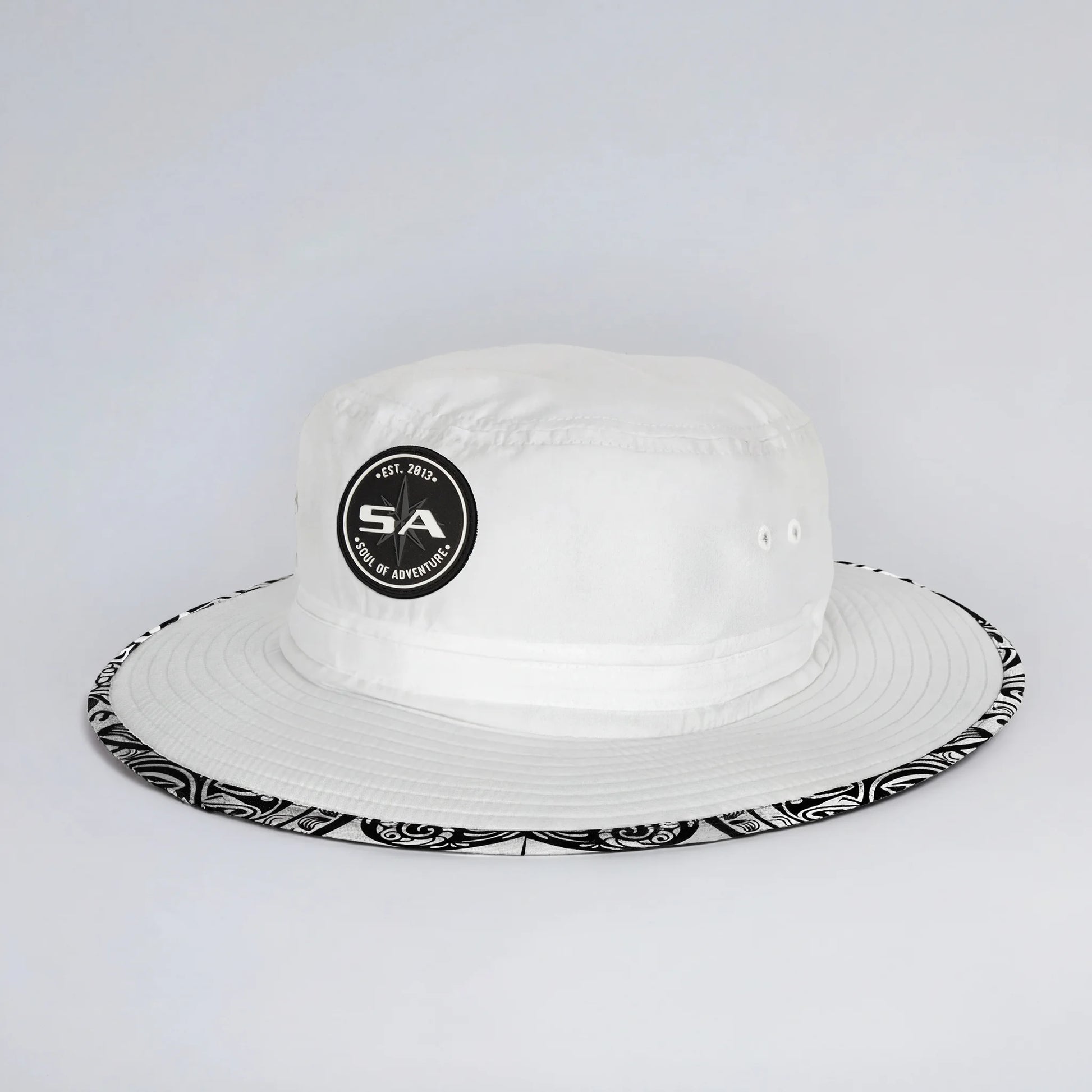 White bucket hat with black and white patterned brim on a light gray background