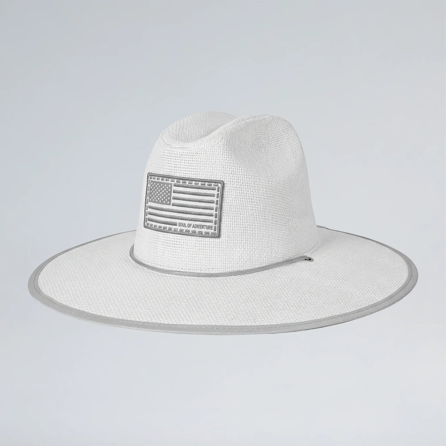 White straw hat with American flag patch on a light gray background