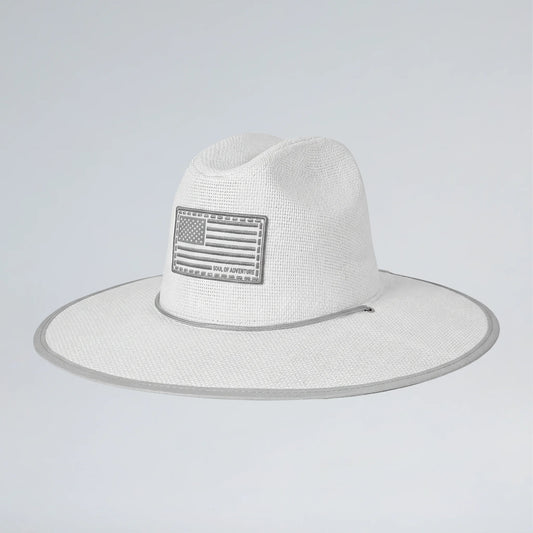 White straw hat with American flag patch on a light gray background
