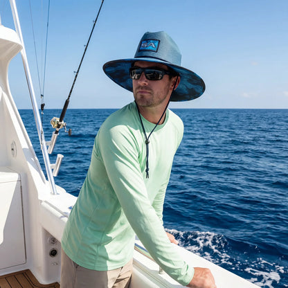 Man on a boat wearing a blue hat and sunglasses with a blue ocean background