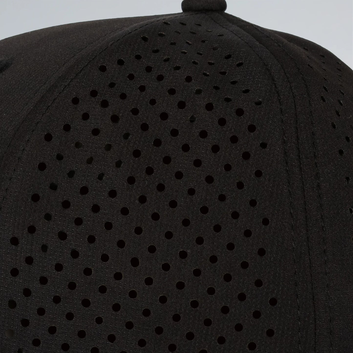 Black cap with perforated design on a gray background