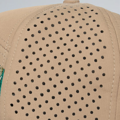 Beige cap with black perforated pattern on a light gray background