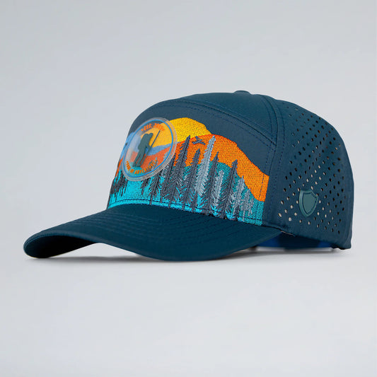 Blue cap with mountain and sun design on a light gray background