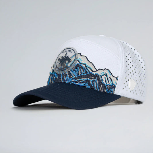 White and navy cap with mountain design on a light gray background