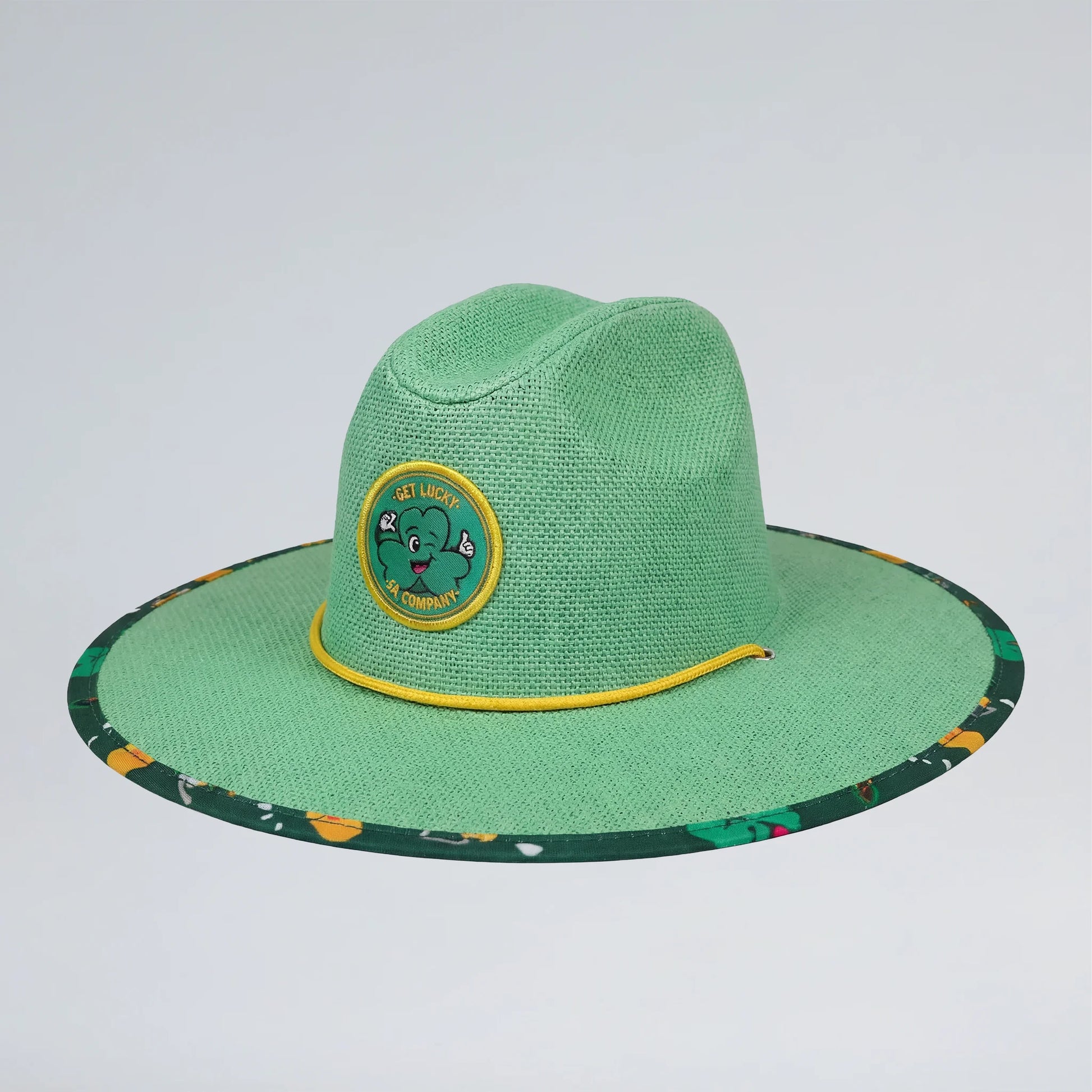 Green straw hat with a circular emblem on a light gray background