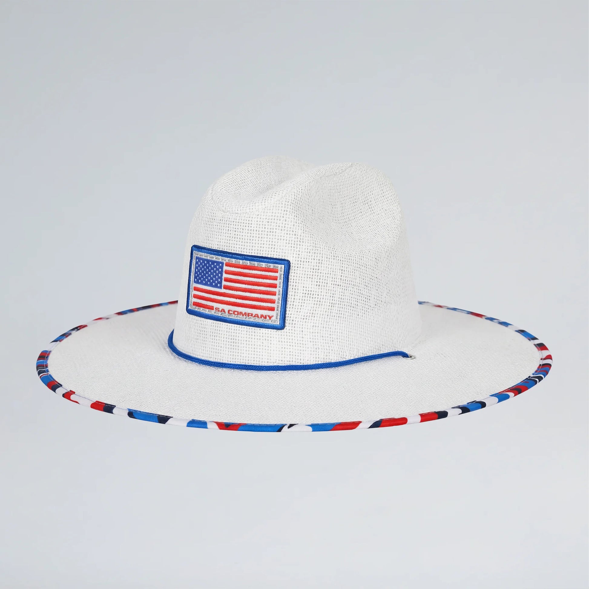 White straw hat with American flag patch and colorful band on a light gray background