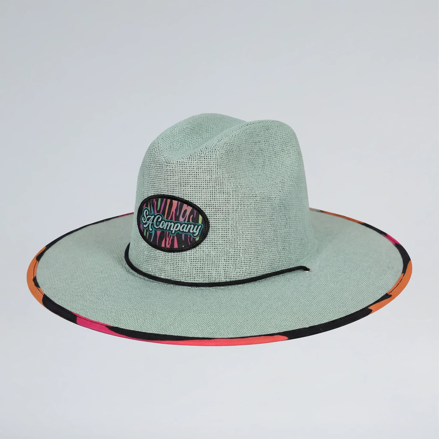 Green straw hat with colorful band on a light gray background