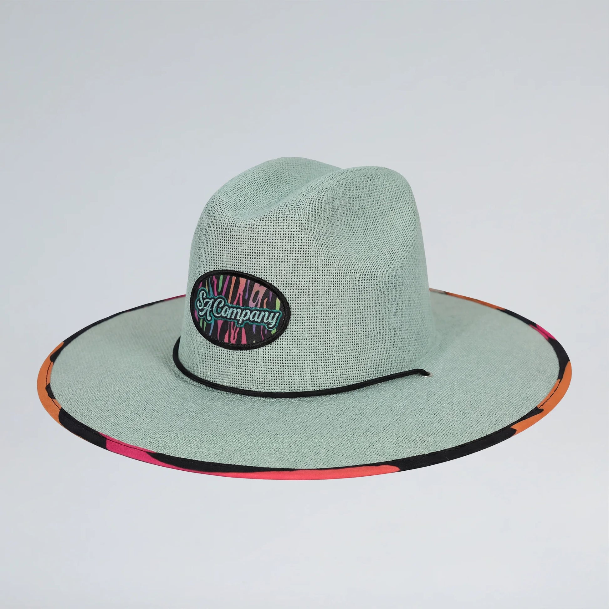 Green straw hat with colorful band on a light gray background