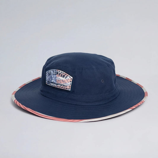 Navy bucket hat with a patch on a light gray background