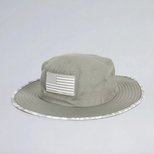 Khaki bucket hat with American flag patch on a light gray background