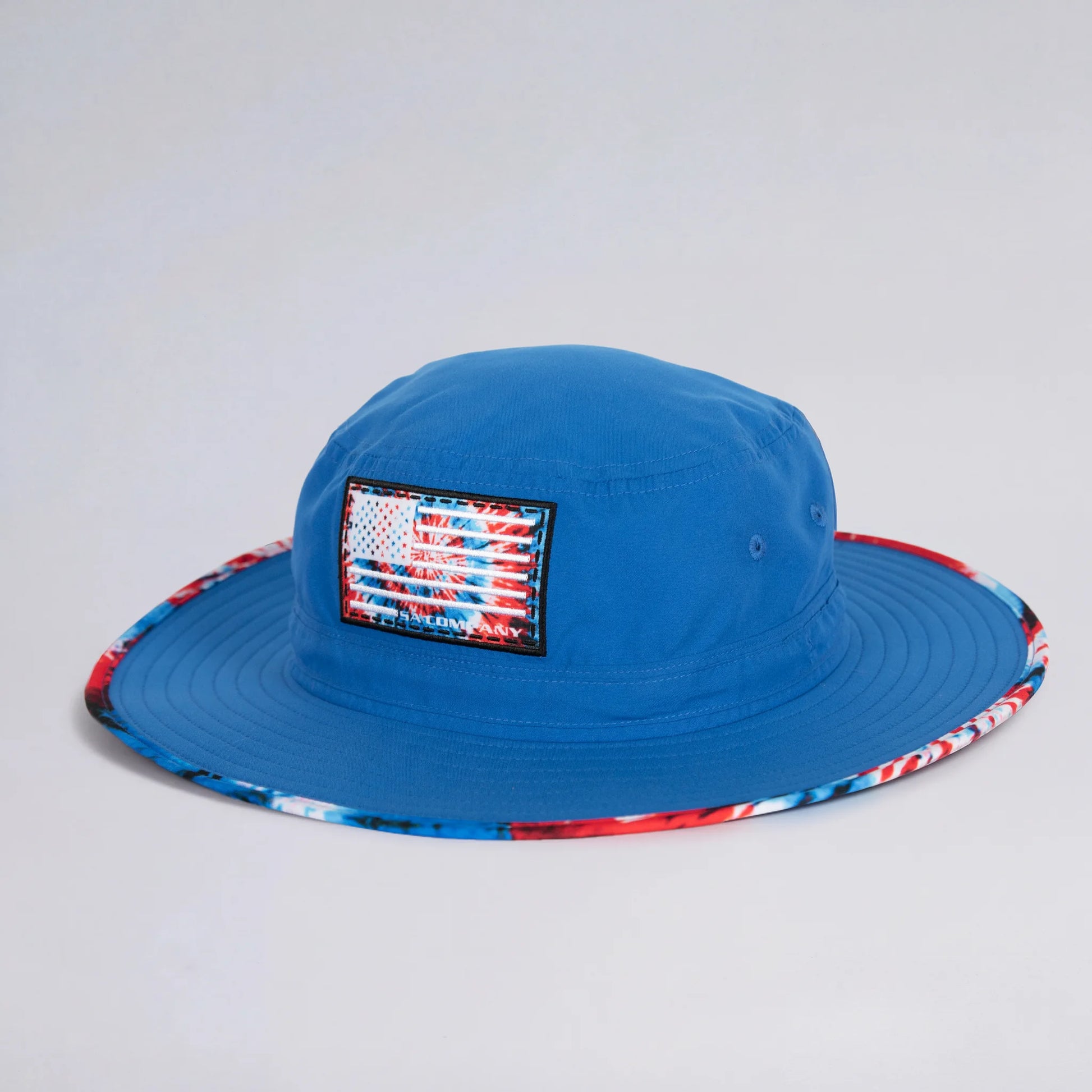 Blue bucket hat with American flag patch on a light gray background