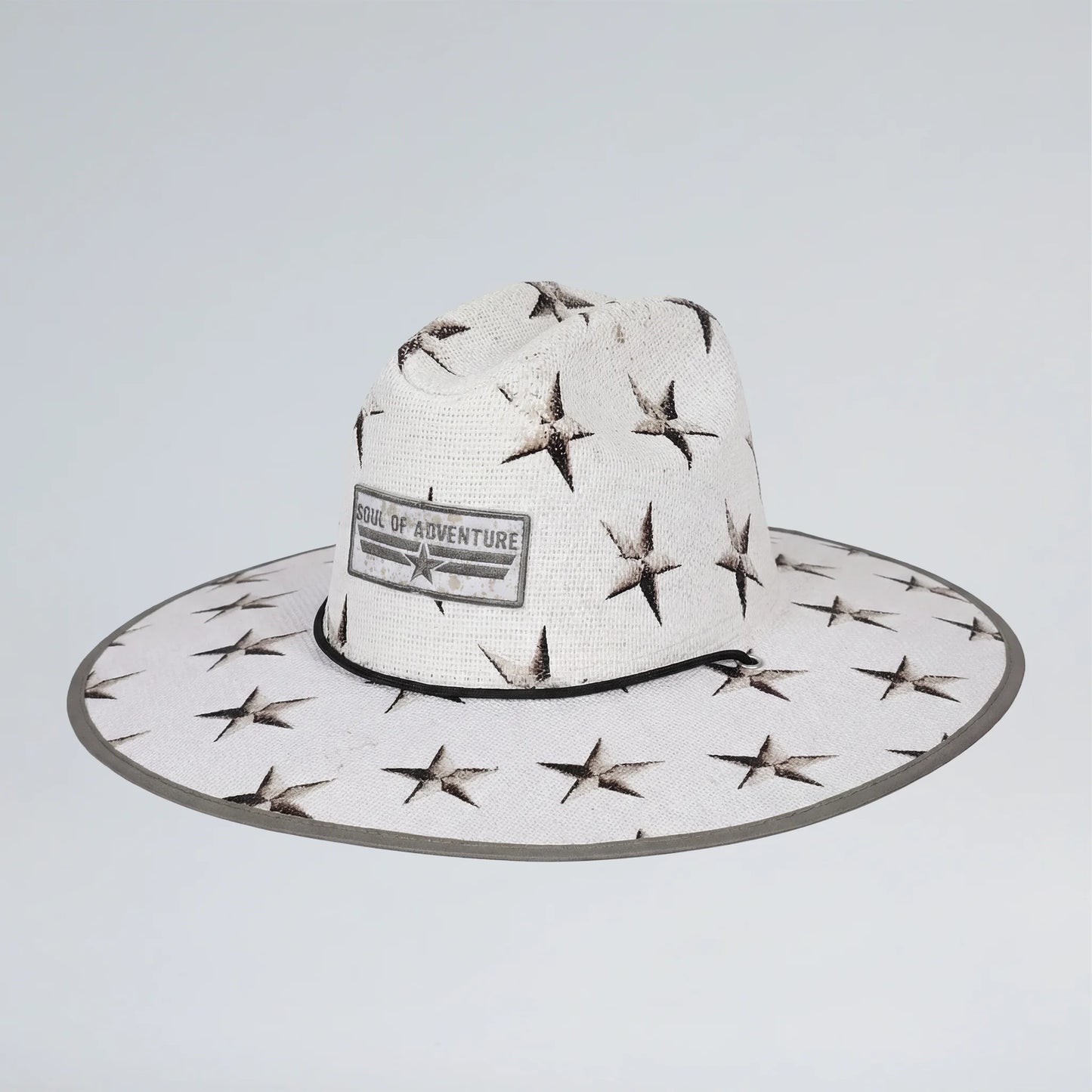 White sun hat with star patterns and 'School of Adventure' label on a light gray background