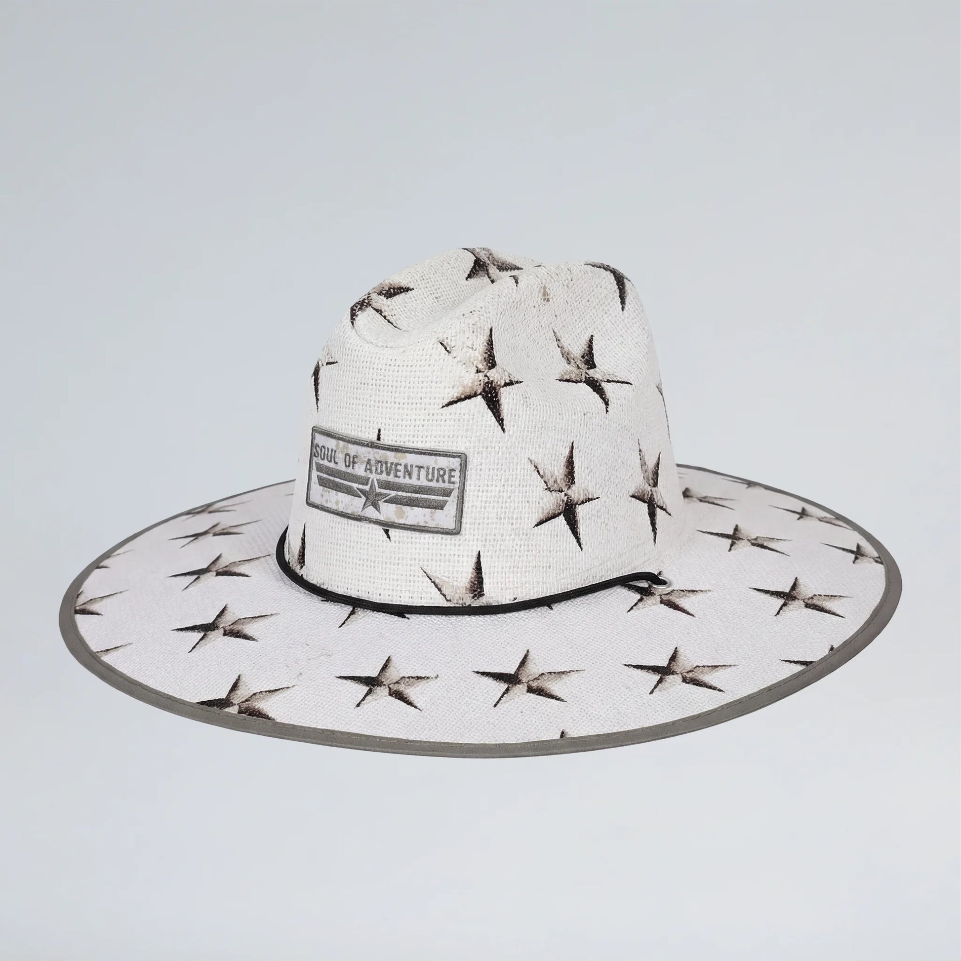 White sun hat with star patterns and 'School of Adventure' label on a light gray background