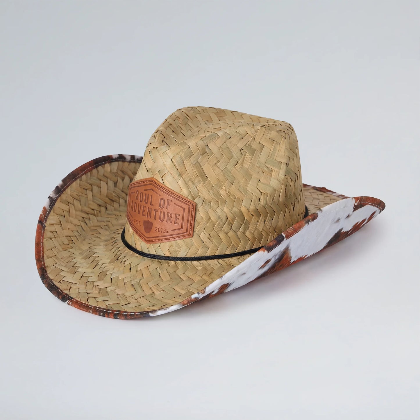 Straw cowboy hat with leather patch on a white background