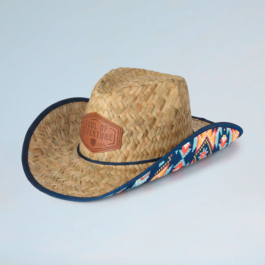 Straw cowboy hat with a colorful band and leather patch on a light blue background