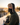 Man on a snowmobile wearing a fleece neck gaiter and trapper hat